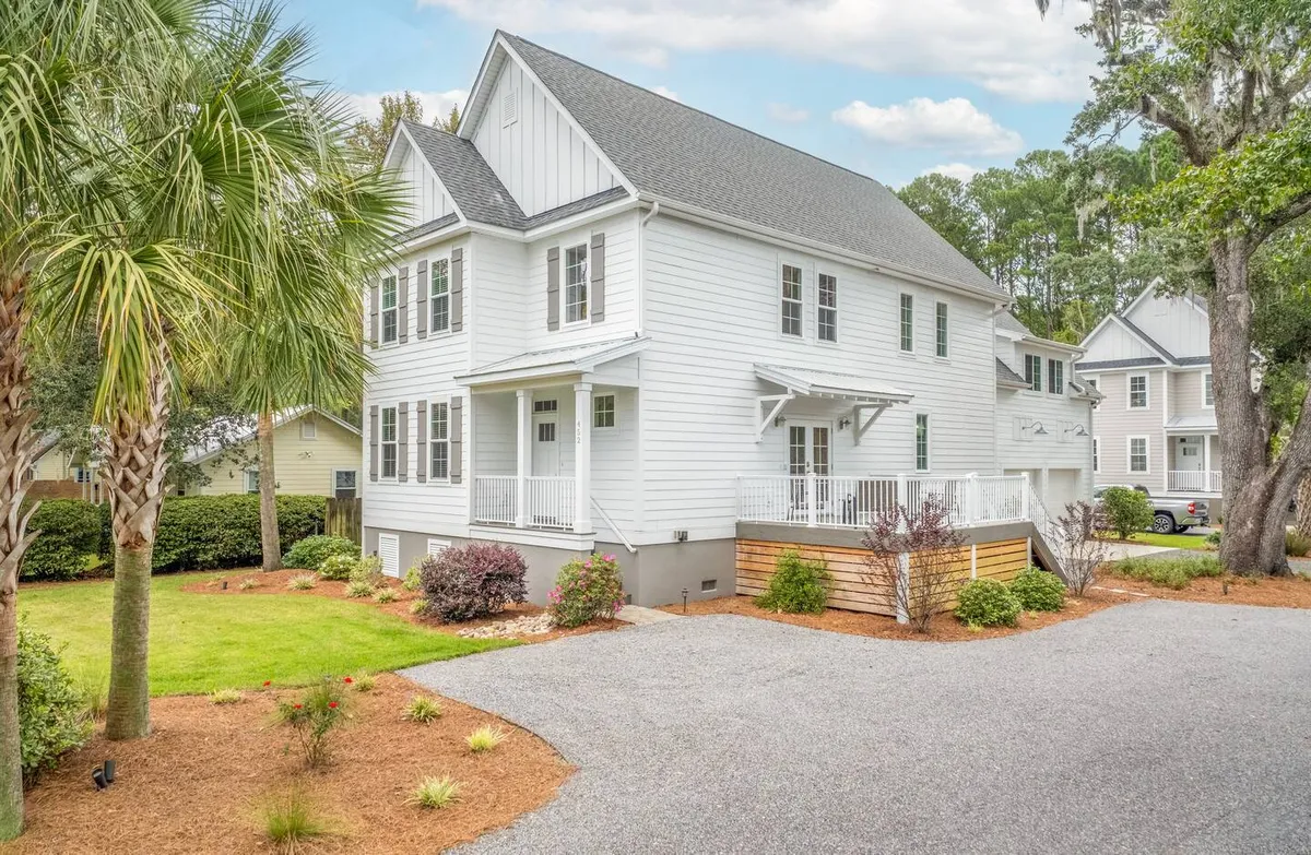 A serene view of the home's front porch, beautifully landscaped yard, and swaying palm trees. The scene is tranquil, suggesting early mornings or relaxed evenings spent enjoying the fresh air—an inviting base for guests eager to explore the surrounding natural attractions.