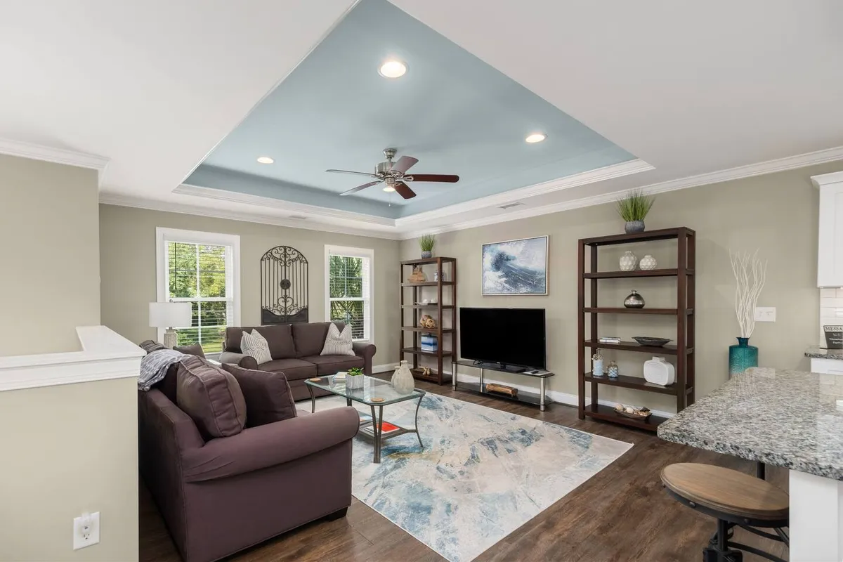 A comfortable, open-concept living area with a sofa, coffee table, TV unit, and decorative wall art. The space feels inviting, perfect for relaxing or entertaining, and features modern decor blending style and comfort.