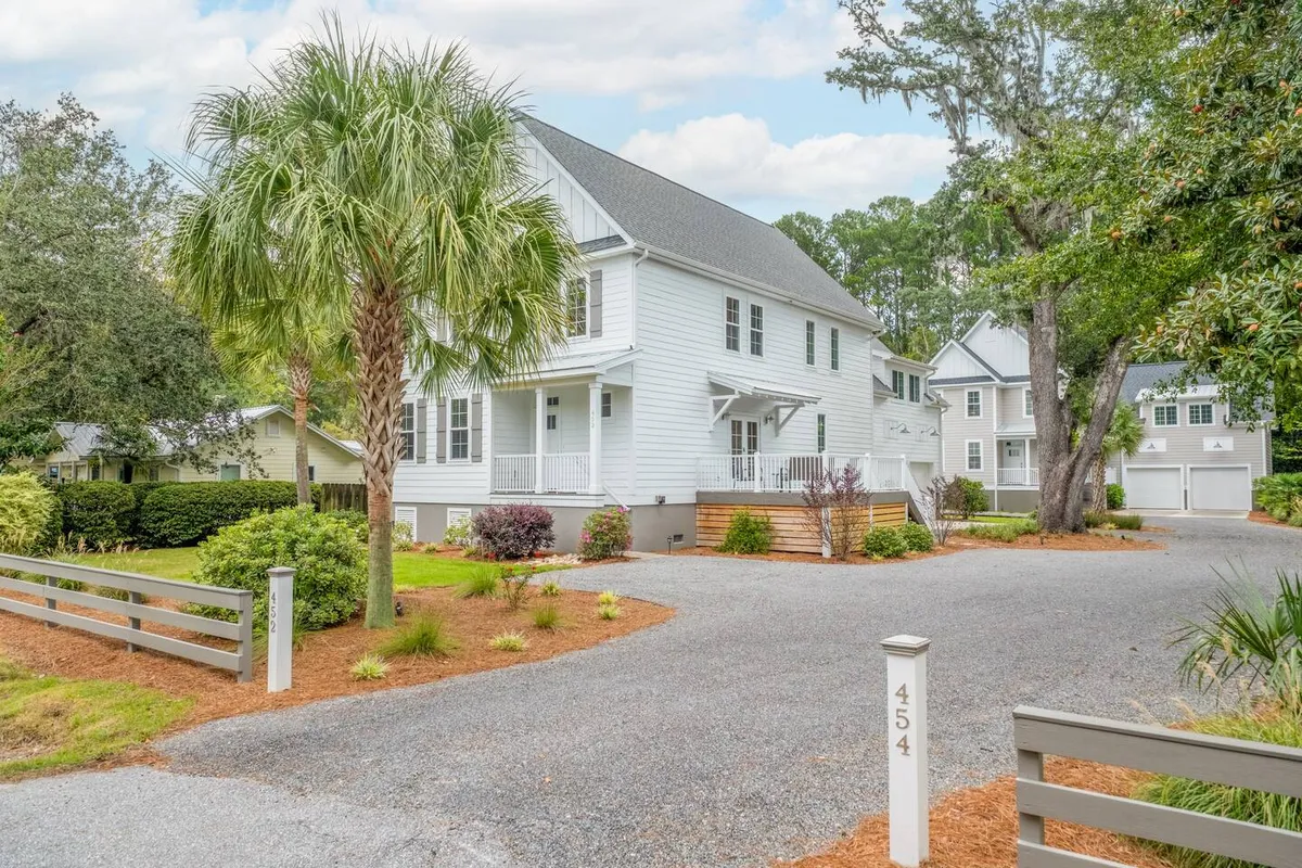This exterior image presents the inviting front porch of the property, shaded by a palm tree and surrounded by a thoughtfully landscaped garden. The porch is ideal for relaxing after a day out, while the lush greenery hints at the welcoming nature of the island community.